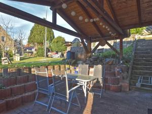 un patio avec une table et des chaises sous un pavillon dans l'établissement Holiday home with terrace and fenced garden, à Naumbourg