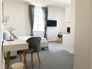Habitación de hotel con cama y escritorio con silla en Best Boarding House, en Hanau am Main