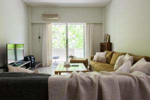 uma sala de estar com um sofá e uma mesa em Lovely Apartment in Athens-Psychiko em Atenas