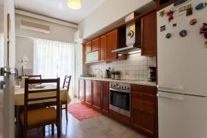 uma cozinha com uma mesa e um frigorífico branco em Lovely Apartment in Athens-Psychiko em Atenas