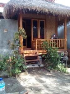 a small house with a thatched roof and a porch at Lombok Collection Gili Air in Gili Islands