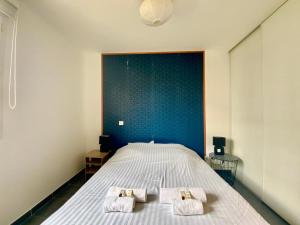 ein Schlafzimmer mit einem Bett mit zwei Handtüchern darauf in der Unterkunft GROOMI Le Port Marianne- Appartement cosy avec 1 chambre in Montpellier