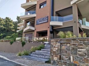 a building with stairs in front of it at Thetis Boutique Apartments in Neos Marmaras