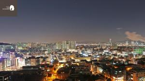 a city lit up at night with buildings at Hotel The Designers Hongdae in Seoul