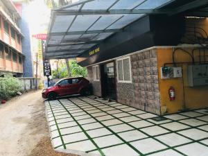 a red car parked outside of a gas station at LAKSHMI TOURIST HOME in Guruvāyūr