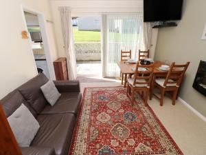 a living room with a couch and a table at Bayview Bungalow in Swansea