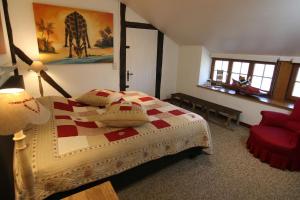 スタヴロにあるGîte La Grande Francorchamps Ardennaiseのベッドルーム1室(ベッド1台、赤い椅子付)
