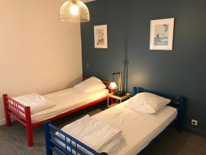 Duas camas individuais num quarto com um candeeiro. em Le Grand Léjon em Pléneuf-Val-André