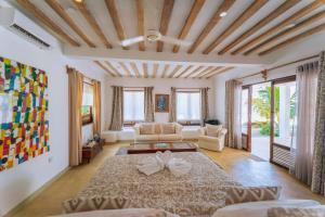 a living room with a large bed and a couch at La Villa de Victor Kigomani in Matemwe