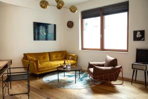 ein Wohnzimmer mit einem gelben Sofa und 2 Stühlen in der Unterkunft Urbn Dreams II in Berlin