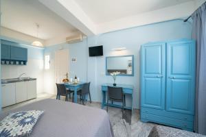 a blue bedroom with a table and a blue cabinet at Prince Studios in Sami