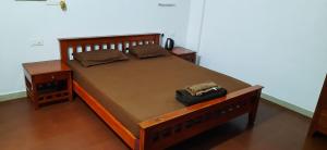 uma cama de madeira com um saco em cima em Poovar Sea View rooms and boating Family & couple only em Pūvār