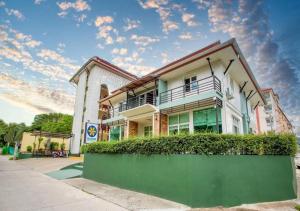 a building with a green hedge in front of it at Bloom Guesthouse in Chiang Mai