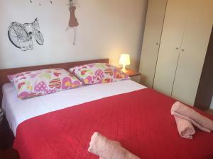 sypialnia z łóżkiem z czerwonym kocem i poduszkami w obiekcie Apartments Roko w mieście Jesenice