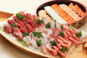 eine Platte mit Sushi und Gemüse auf dem Tisch in der Unterkunft Boso Shirahama Umisato Hotel in Minamiboso