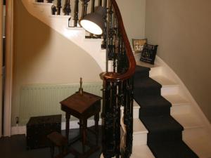 Cheswick的住宿－Broomhouse Farmhouse，螺旋楼梯,配有桌子和灯