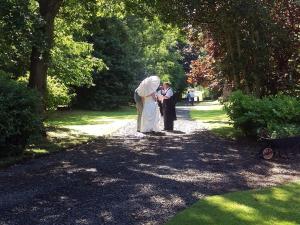 a woman and a man walking down a path in a park at Broomhouse Farmhouse in Cheswick +8 photos