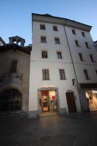 Un alto edificio bianco con un negozio di fronte di DeTillierStudiò ad Aosta