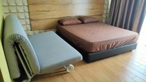 una stanza con due letti e una sedia di Bangi Gateway Suite a Kampong Sungai Merab