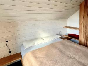 een kleine kamer met een bed in een houten muur bij Ferienhaus Rhöner Wohnen in Hilders