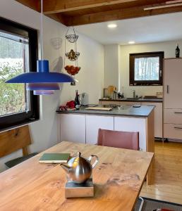 uma cozinha com uma mesa de madeira e um candeeiro azul em Ferienhaus Rhöner Wohnen em Hilders