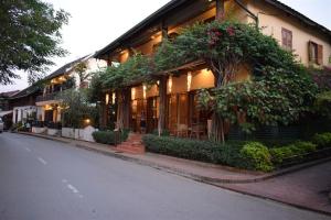 a building with plants on the side of a street at Sala Prabang Hotel in Luang Prabang