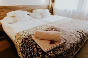 a bed with a towel and a cross on it at Hotel Dębowe Wzgórze Wellness & Spa - zarezerwuj w kwietniu 2 noclegi a wypożyczenie rowerów będzie GRATIS! in Jarnołtówek