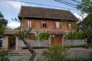 a wooden house with a fence in front of it at Sala Prabang Hotel in Luang Prabang