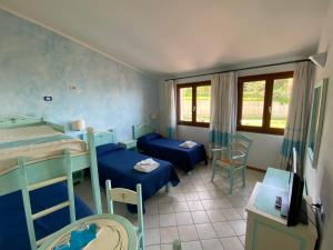 a room with two bunk beds and a table and chairs at La Locanda del Mare in Valledoria