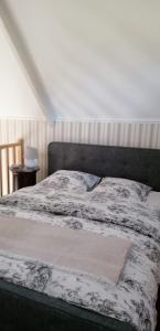 a bedroom with a bed with a black and white comforter at La Chapelle Saint-Nicolas in Cassel