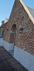 a brick building with a door on the side of it at La Chapelle Saint-Nicolas in Cassel