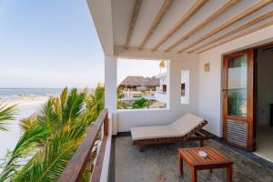 a balcony with a bench and a view of the beach at La Villa de Victor Kigomani in Matemwe