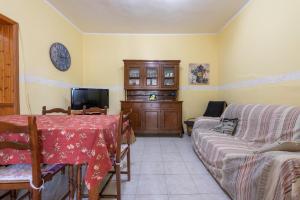 un soggiorno con tavolo e divano di Casa con dependance Gli Agrumi a Villa San Pietro