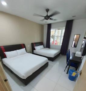 a bedroom with a bed and a couch and a chair at KompoVilla in Kuantan