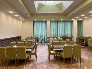 a dining room with tables and chairs and a skylight at Yerevan Resident Hotel in Yerevan