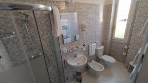 a bathroom with a sink and a toilet and a shower at Albergo Moderno in Lucca