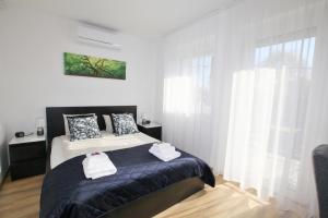 1 dormitorio con 1 cama con 2 toallas en Paskal-Lux Family Apartments with free parking en Budapest