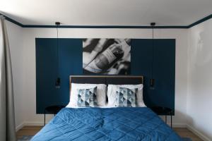 a bedroom with a blue bed with a picture on the wall at KRACHER Ferienhaus Landhaus No 1 in Illmitz