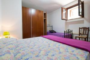 sypialnia z łóżkiem, oknem i krzesłem w obiekcie Case Vacanze San Gregorio by LoveSud w mieście Patù