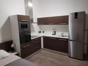 a kitchen with brown cabinets and a stainless steel refrigerator at Velký apartmán Sophia (s infrasaunou) č. 1 in Velké Losiny