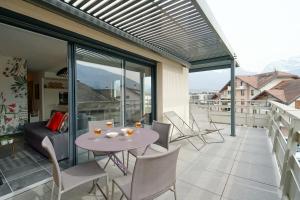 een patio met een tafel en stoelen op een balkon bij Le Saint-Jore - 2 bedroom apartment balcony & parking in Saint-Jorioz