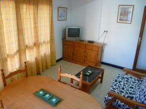 a room with a table and a television on a dresser at Estirpe, 3º-5 in Cullera