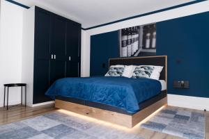 イルミッツにあるKRACHER Familienapartment Landhaus No 4 - inklusive Poolの青い壁のベッド付きの青いベッドルーム1室