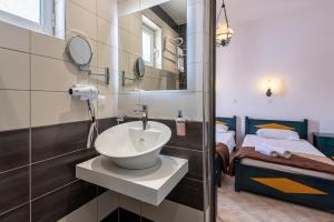 a bathroom with a sink and a mirror and a bed at Cirillo Family Hotel-Christinas Studios in Mastihari