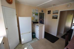 a kitchen with a white refrigerator and a stove at Cottage - Whanarua Bay Cottages in Te Kaha