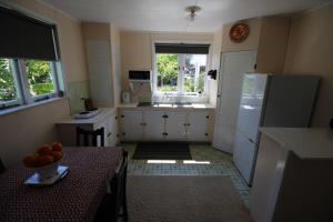 a small kitchen with a table and a refrigerator at Cottage - Whanarua Bay Cottages in Te Kaha