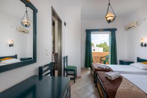 a room with two beds and a table and chairs at Cirillo Family Hotel-Christinas Studios in Mastihari