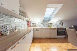 a kitchen with white cabinets and a skylight at Villa DonLeone in Ponikva