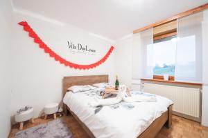a bedroom with a bed with a red garland on the wall at Villa DonLeone in Ponikva