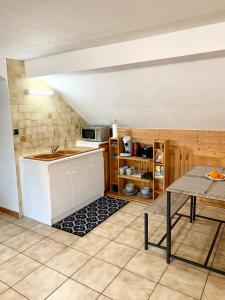 - une cuisine avec un évier et une table dans l'établissement Charmant appart sous toits proche Château des Ducs, à Chambéry